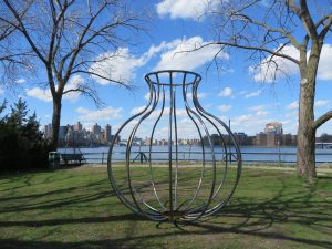 Maren Hassinger 9' steel linear sculpture, gourd-shape with the East River and city skyline behind it.